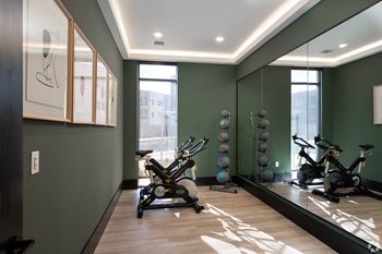 A room with exercise equipment and a mirror on the wall.